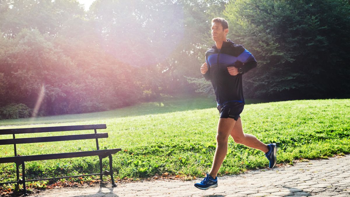 Runner training in hot sunny conditions on an open road